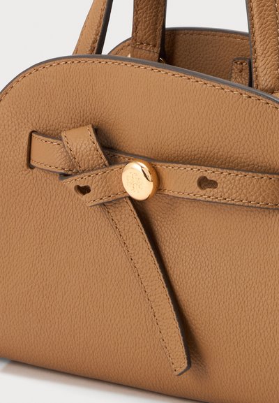 Sac à main en cuir texturé couleur tabac avec un dessus arrondi et une lanière en cuir passée à travers un bouton doré à l'avant.