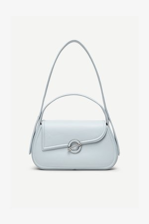 Lyseblå lædertaske med rundet flap, sølvfarvet cirkulært lås og to skulderstropper mod en ensfarvet baggrund.