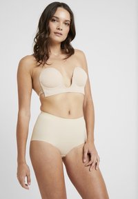 Beige strapless bra with smooth, molded cups and side hooks paired with high-waisted beige briefs, both in a seamless, soft fabric.