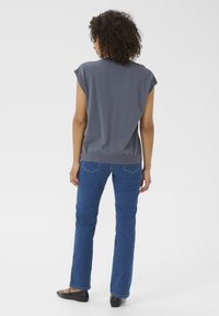 Grå kort�ærmet top, slim fit, med rund halsudskæring, parret med blå lige ben jeans og sorte flade sko. Minimalistisk design uden mønstre.