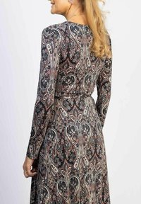 Musta pitkähihaisessa mekossa on monivärinen paisley-kuosi. Mekossa on istuva vyötärö ja virtaava hame. Sileä tekstuuri.