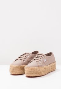 Beiga kanvas plattformssneakers med vävda jutesulor, med snörning och silverfärgade öglor. Slät textur, upphöjd design.