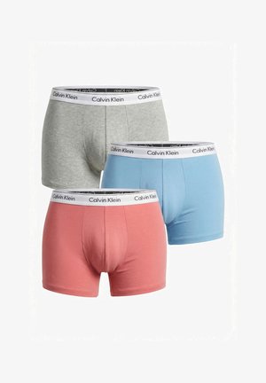Lot de trois boxers pour hommes Calvin Klein en gris, bleu et corail avec des ceintures blanches à logo, présentés sur fond blanc.