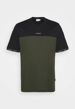 Kurzärmliges T-Shirt mit einem schwarzen oberen Bereich und einem olivgrünen unteren Bereich, mit weißem Logo und Akzenten auf den Ärmeln. Aus Baumwolle.