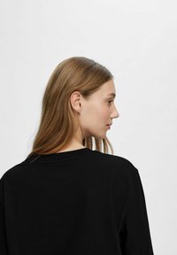 Schwarzer Sweatshirt mit Rundhalsausschnitt und langen Ärmeln, aus weicher Baumwolle mit glatter Textur und minimalistischem Design.
