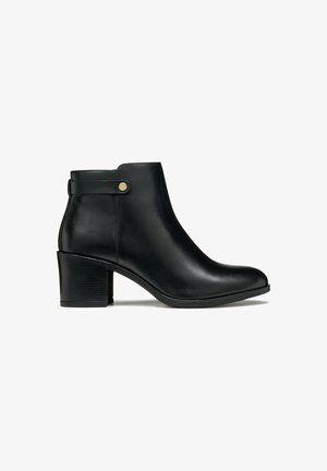 Botte de cheville en cuir noir avec un bout rond, un talon bloc et une sangle latérale avec un accent doré. Texture lisse, design élégant.