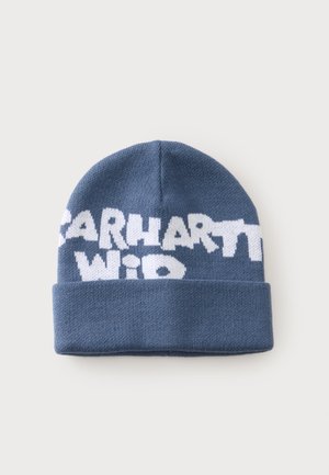 Blå strikket hue med ombukket kant og hvid tekst, der delvist læser "Carhartt WIP" over fronten.