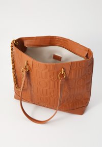 Bolso tote de cuero marrón con relieve y acentos de cadena en tono dorado, apertura superior y forro interior beige. Cuenta con la marca texturizada "Juju".