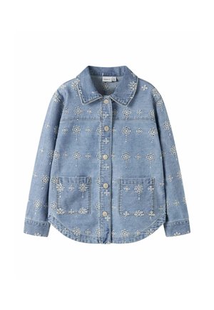 Veste en denim bleu clair avec broderie florale blanche, boutonnage sur le devant, deux poches avant et un col classique.