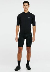 Maillot de cyclisme noir à manches courtes avec une fermeture éclair à l'avant. Cuissard de cyclisme noir assorti avec une coupe ajustée. Tissu texturé.