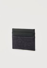 Melns plāns karšu turētājs ar trim karšu nodalījumiem, apakšējā pusē ar smalku rakstainu audumu un augšējā pusē ar gludu materiālu.