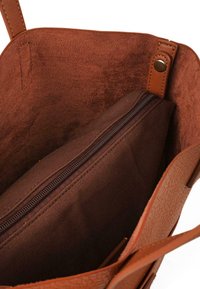 Bolso tote marrón con exterior de cuero texturizado. El interior cuenta con un forro de tela suave y un bolsillo con cremallera para almacenamiento.