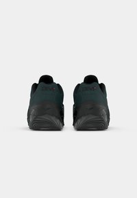 Crne i tamnozelene atletske cipele s teksturiranom gumenom potplatom, zaobljenim petama i glatkim gornjim dijelom. Imaju "am" brendiranje i Nike logo na peti.