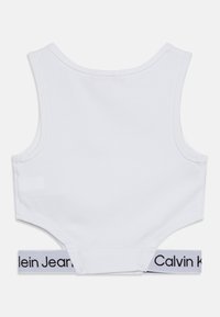 Witte katoenen bralette met een afgeronde halslijn en brede bandjes, voorzien van een zwarte en witte Calvin Klein elastische band aan de onderkant.
