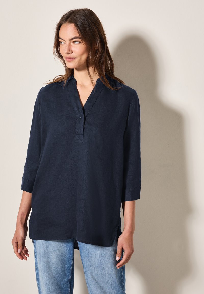 Camicia di lino blu navy con colletto e patta bottonata, dotata di maniche a tre quarti e vestibilità rilassata. Tessuto testurizzato con spacco laterale.
