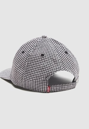 Gorra de béisbol de cuadros blancos y negros con correa ajustable y pequeña etiqueta roja de Levi's en la parte trasera sobre fondo liso.