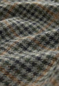 Strukturierter Stoff in Grünt�önen, Braun und Schwarz mit einem fuzzy Aussehen, das ein komplexes, geschichtetes Muster aufweist. Weiches und dickes Material.