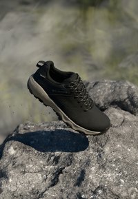 Schwarzer Laufschuh mit Mesh-Obermaterial, strukturiertem Oberflächenfinish und Gummisohle; bietet ein niedriges Profil und eine verstärkte Zehenkappe.