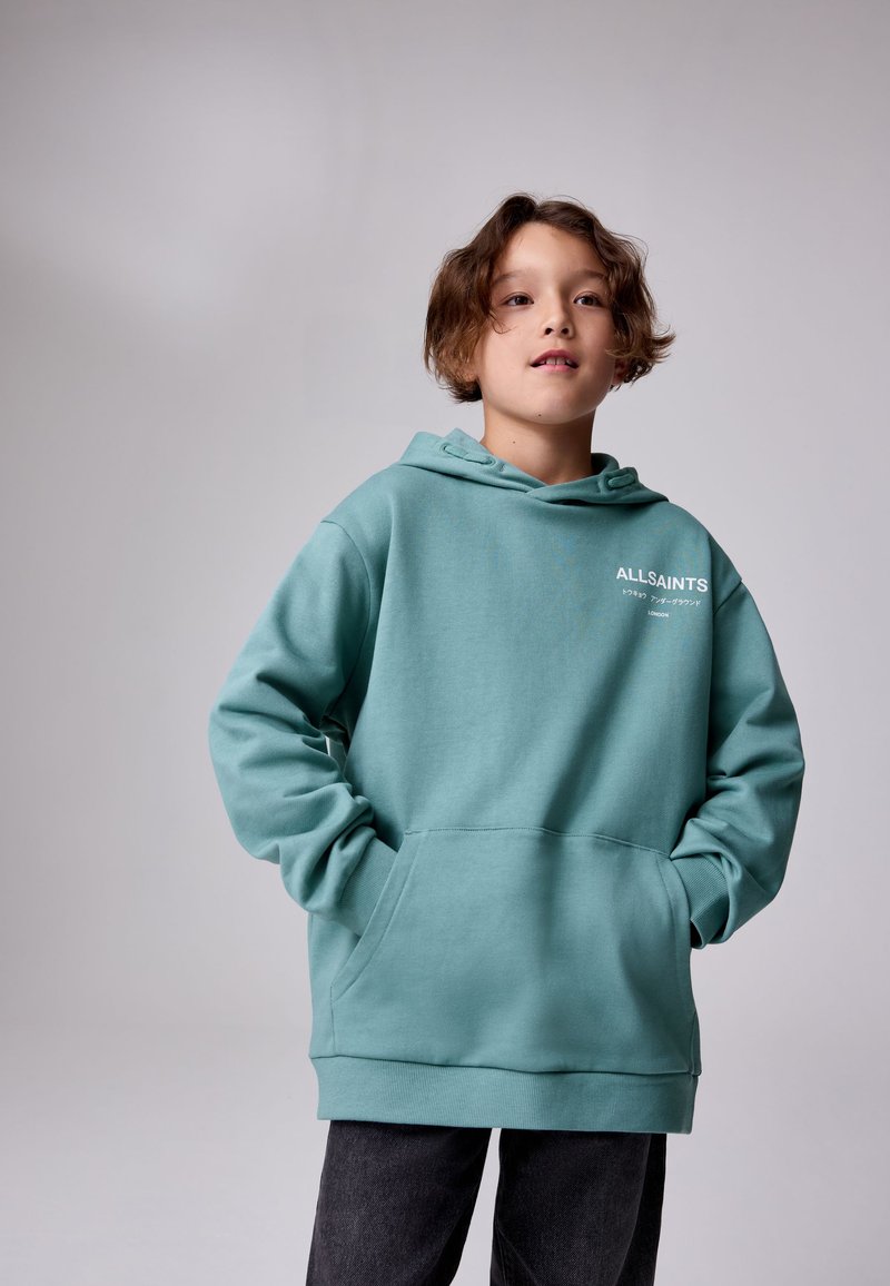 Világos tengerzöld kapucnis pulóver, puha anyagból készült. Kanguru zsebbel, bordázott mandzsettákkal és az "ALLSAINTS" logóval a bal mellrészen.