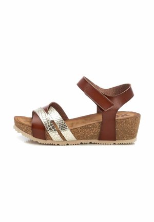 Sandalias de cuña de cuero marrón con una correa plateada texturizada. Presentan una suela de corcho y una correa trasera ajustable. Diseño de punta redondeada.