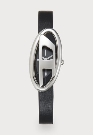 Silberfarbene ovale Uhr mit einem markanten "A"-Design, schwarzem Zifferblatt und Lederarmband. Verfügt über minimalistische Stundenmarkierungen und Zeiger.