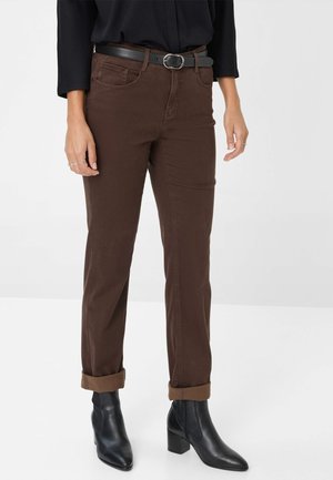 Bruine katoenen broek met een rechte pasvorm, voorzien van opgerolde manchetten en zijzakken, gecombineerd met zwarte hoge enkelboots.