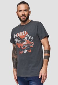 Grå bomulds t-shirt med et vintage Ford Cortina motiv i orange og hvid, med ternede flag i baggrunden. Korte ærmer.