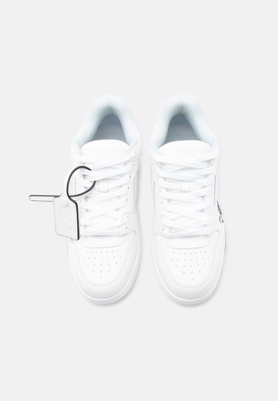 Ζευγάρι καθαρά λευκά χαμηλοτάκουνα αθλητικά παπούτσια με οπές στα δάχτυλα και λευκή ετικέτα με μαύρο περίγραμμα προσαρτημένη στα κορδόνια του αριστερού παπουτσιού.