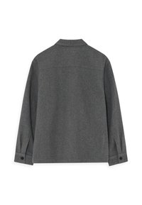 Jachetă din lână gri, cu guler, mâneci lungi, manșete cu nasturi și o textură netedă. Partea din spate prezintă un detaliu de yoke.