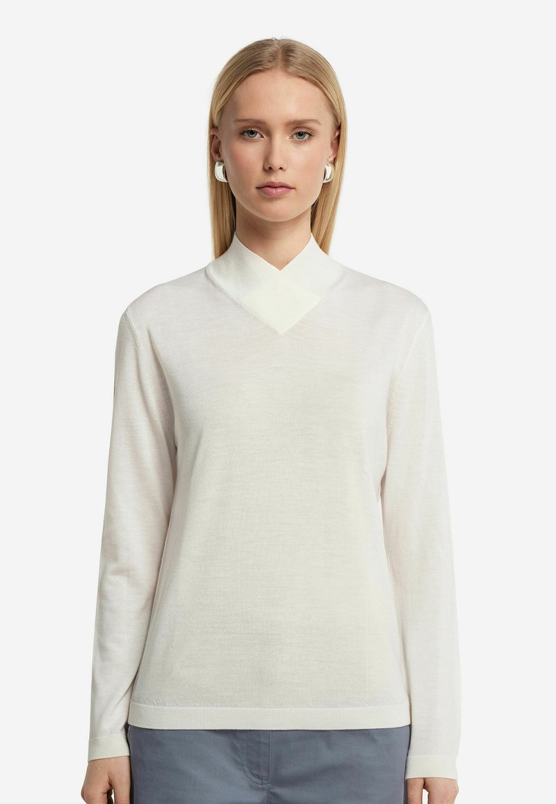 Weißes Langarmshirt mit V-Ausschnitt, weichem Material und gerippten Bündchen. Mit einem geschichteten Kragen für zusätzliche Details gestylt.