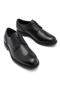 Pantofi de piele negri cu o finisare texturată, cu vârful rotund, un design cu șireturi și o talpă netedă din cauciuc negru.