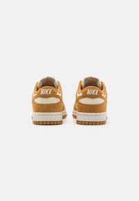 Nike Dunk jooksujalatsid oranžist seemisnahast, valgete aktsentidega, pehmendatud kaelusega ja struktuurse kummist tallaga. Sobilikult on kanna peal "NIKE" bränding.