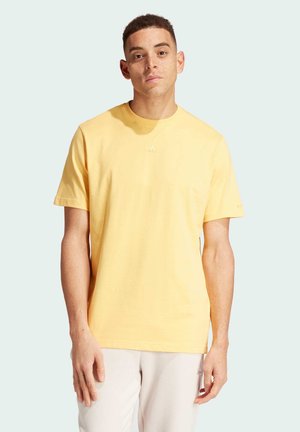 T-shirt di cotone giallo con maniche corte e collo rotondo. Presenta un piccolo logo sul petto e una vestibilità rilassata. Tessuto morbido.
