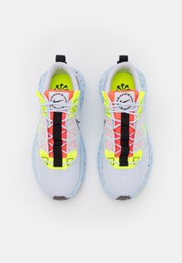 Lätta löparskor med överdel i mesh i vitt, accentuerade med neongula och rosa snören. Har svart kant och en fläckig blå sula.