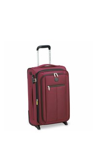 Valigia con ruote color marrone scuro, dotata di manico in plastica nera, doppie cerniere, tasca anteriore e finitura in tessuto texturizzato. Presenta un manico laterale e protezioni angolari.