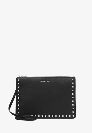 Czarna kopertówka typu wristlet marki Michael Kors z srebrnymi kwadratowymi ćwiekami wzdłuż krawędzi i paskiem na nadgarstek przymocowanym z jednej strony.