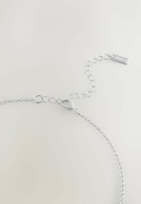Zilveren ketting met een lobster clasp en een verstelbare lengte, cirkelvormige schakels, een gladde textuur en een minimalistisch ontwerp.