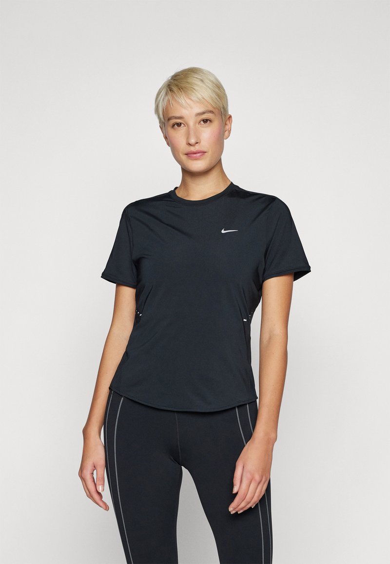 T-shirt de sport noir à manches courtes, col rond et logo Nike réfléchissant sur la poitrine. Tissu lisse avec une coupe ajustée.