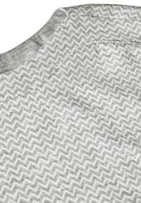 Grijs textiel met een zigzagpatroon, met een gladde textuur en een ronde halslijn. Gestikte naden zijn zichtbaar.