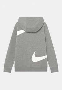 Grå hoodie i bomullsblandning med en stor vit Nike-logotyp på baksidan och ett mjukt, strukturerat tyg. Huva med ribbad mudd.