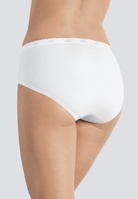 Slip in cotone bianco con una texture liscia, dotato di una fascia in pizzo con bordo scallop e un design che offre piena copertura. Vista posteriore mostrata.