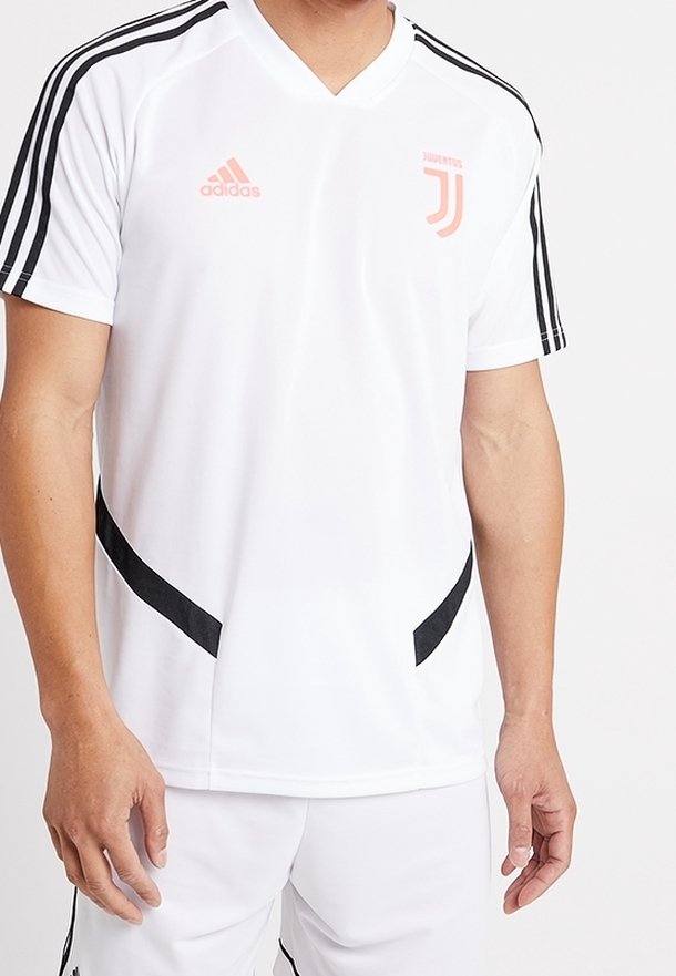 Vit sporttröja med svarta och persikofärgade accenter, med V-ringning och tre svarta ränder på varje axel. Logotyp på bröstet.