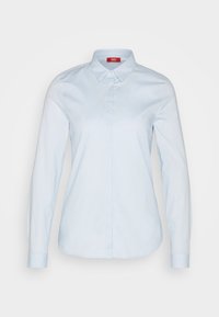 Chemise bleu clair à manches longues, boutonnée à l'avant avec col pointu et boutons dissimulés, présentée sur un fond uni.