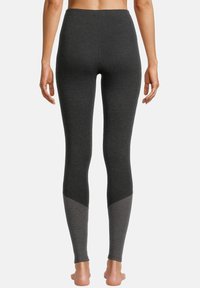 Grå leggings med hög midja som har en texturerad, tvåfärgad design; mörkare grå huvudfärg och ljusare grå detaljer vid anklarna.