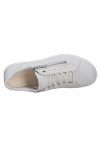 Zapatilla blanca de cuero con superficie texturizada, que cuenta con cordones en la parte delantera, cremallera lateral y una suela de goma de perfil bajo. Nombre de la marca visible en el interior.