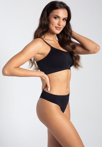 Czarny top crop i pasujący zestaw bikini z wysokim stanem, wykonany z gładkiego materiału, z cienkimi ramiączkami i minimalistycznym designem.
