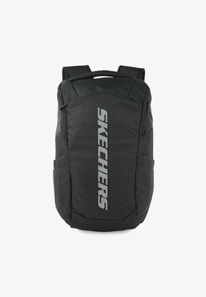 Mochila negra con correas acolchadas, un compartimento principal grande y bolsillos laterales. Presenta un prominente logo plateado de "SKECHERS" en la parte frontal.