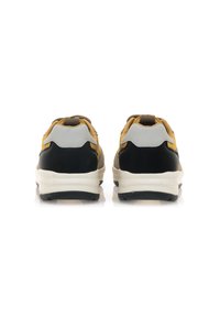 Sneaker neri, gialli e grigi con un design testurizzato, dotati di una suola in gomma bianca spessa e pannelli del tallone rinforzati.