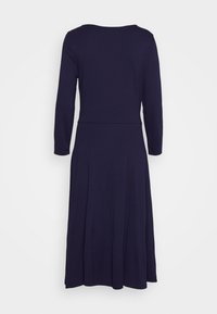 Granatowa sukienka z długim rękawem, okrągłym dekoltem, dopasowaną talią i rozkloszowanym dołem. Materiał wygląda na gładki o miękkiej fakturze.