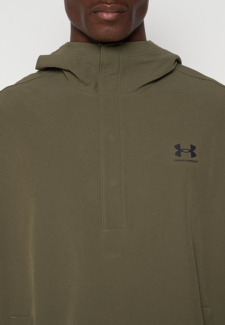 Sudadera con capucha de color verde oliva y media cremallera en la parte delantera. Cuenta con un pequeño logo negro de Under Armour en el pecho y una textura suave y mate.